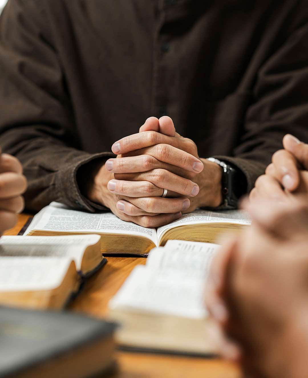 men with bible saying a prayer