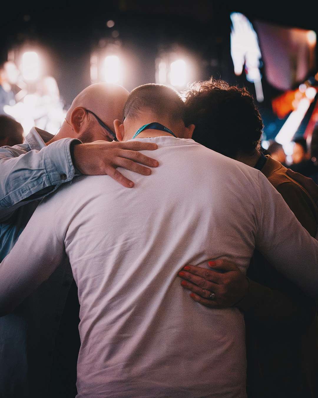 three men praying together at 1613 Men's Conference